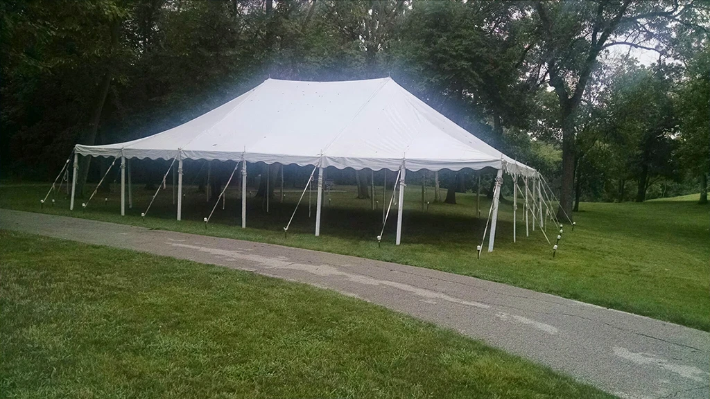 Outdoor pole tent installed near trees and open green space